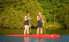 Två tjejer paddlar SUP från KAYAKOMAT